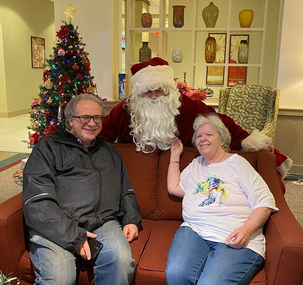 Residents interacting with Santa in the common area.