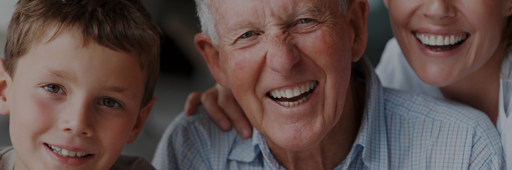 Smiling senior with child and caregiver