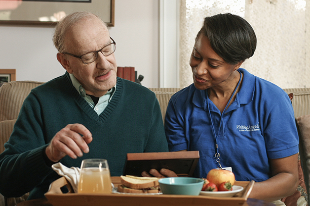 Caregiver and resident sharing a meal together