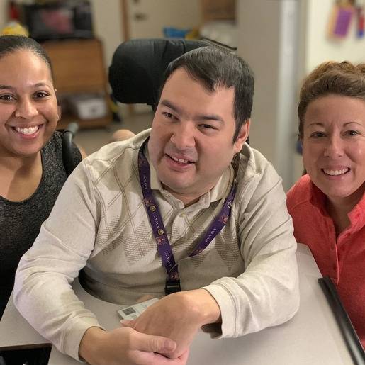 Three people smiling in a facility setting.