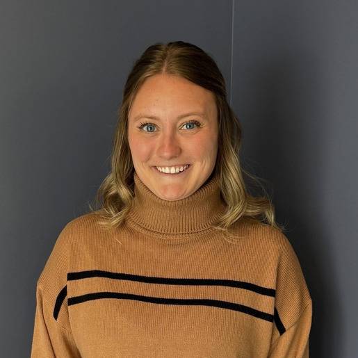 Smiling staff member in a sweater