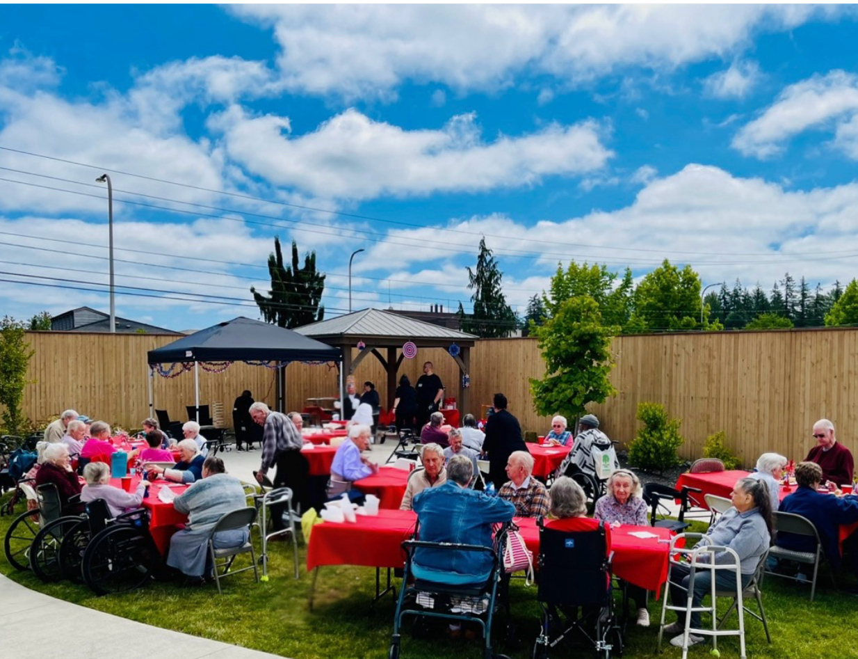 Residents enjoying an outdoor gathering with tables and decorations