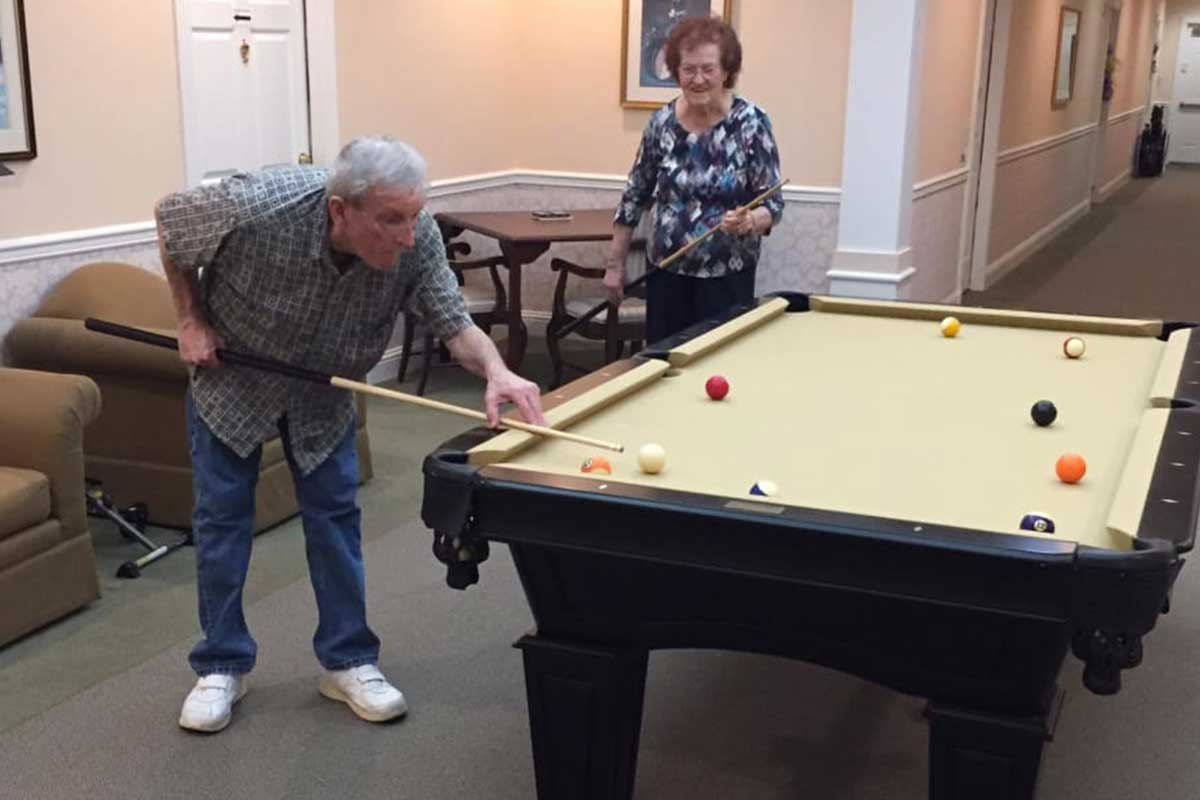 Residents playing billiards in a common area