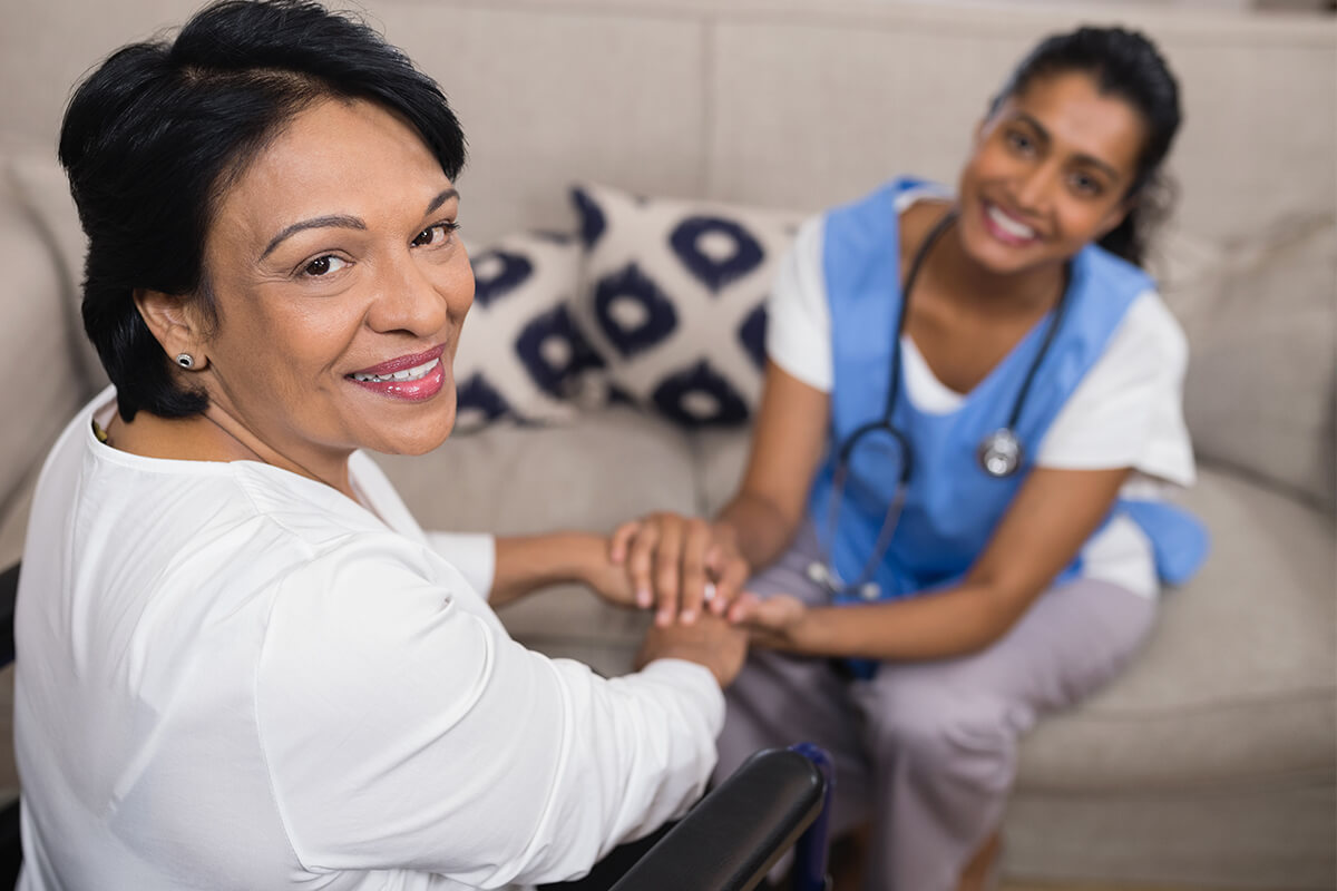 A caregiver holding hands with a resident in a cozy interior