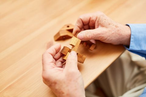 Resident engaging with a wooden puzzle activity