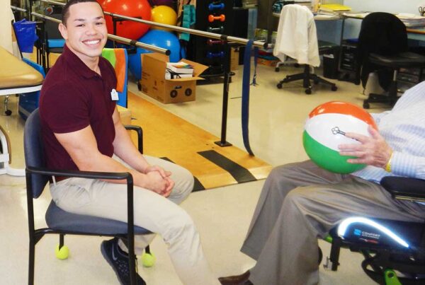 Staff member engaging with a resident in an activity room