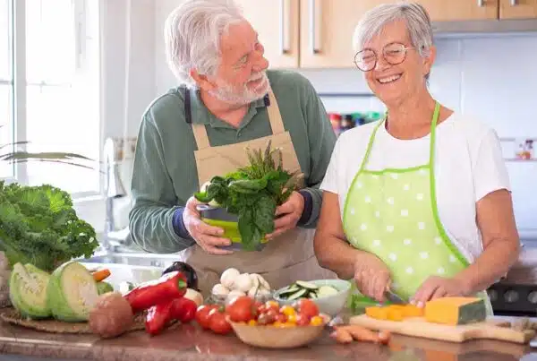 Seniors cooking together with fresh vegetables