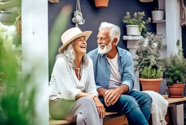 Two seniors laughing together in a garden setting