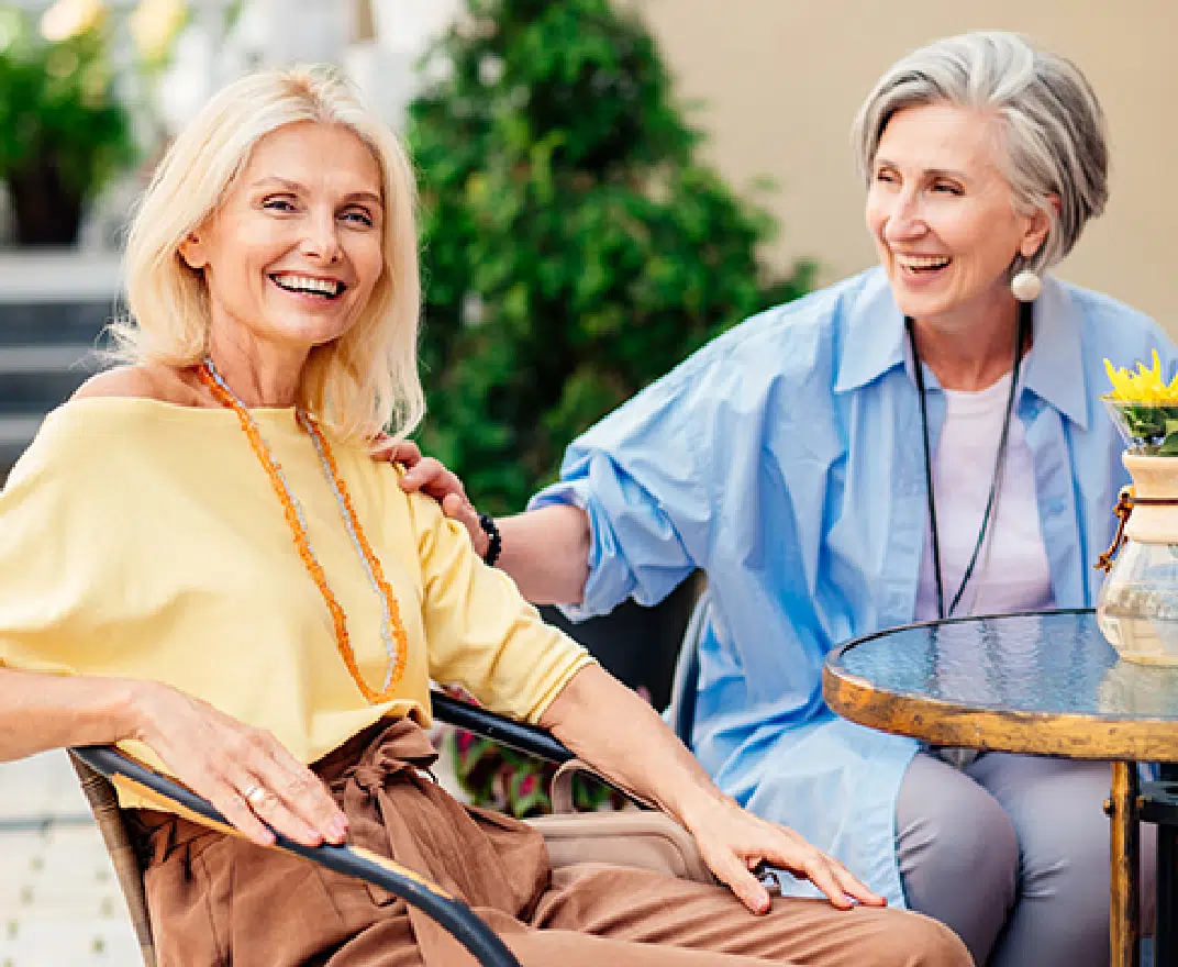 Two women enjoying a sunny outdoor space together