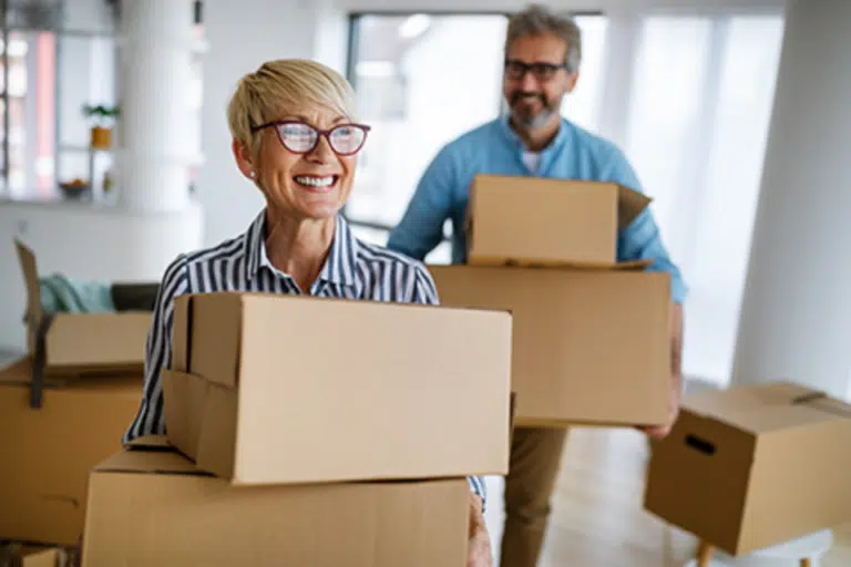 Residents moving boxes into a bright common area