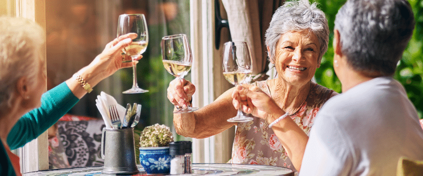 Residents toasting with wine glasses at a table