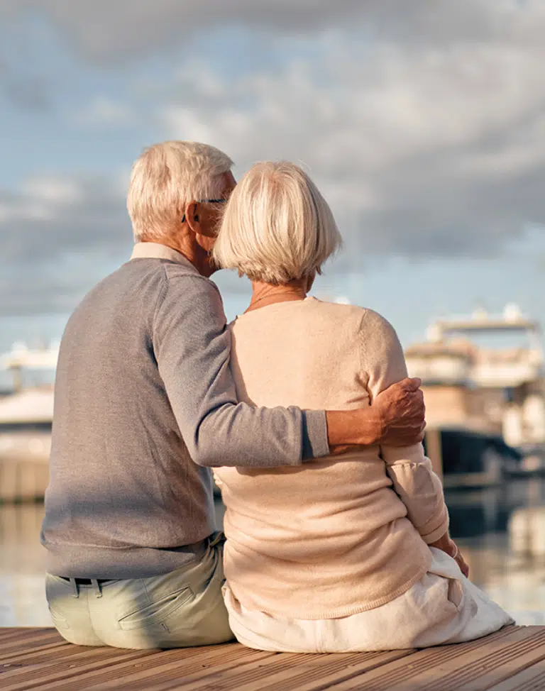 Elderly couple sitting by the water