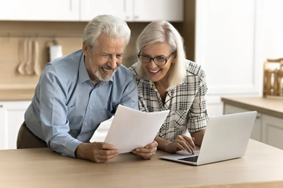 Couple smiling while reviewing documents at a desk