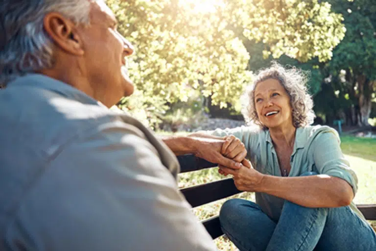 Two seniors enjoying conversation in a garden