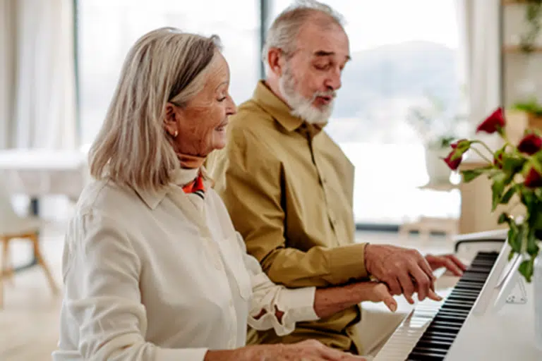 Residents enjoying a music activity together at a piano