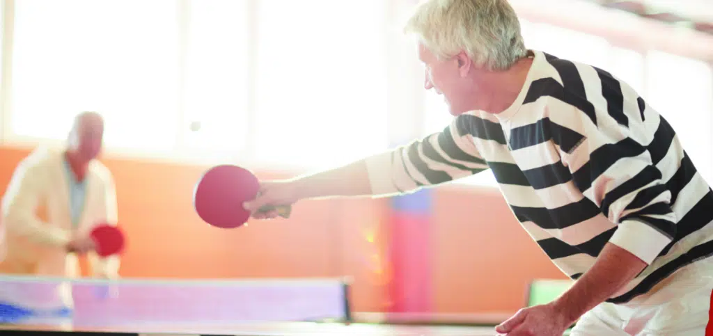 Residents playing ping pong in an activity room