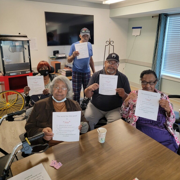 Residents participating in an activity, holding papers with words.