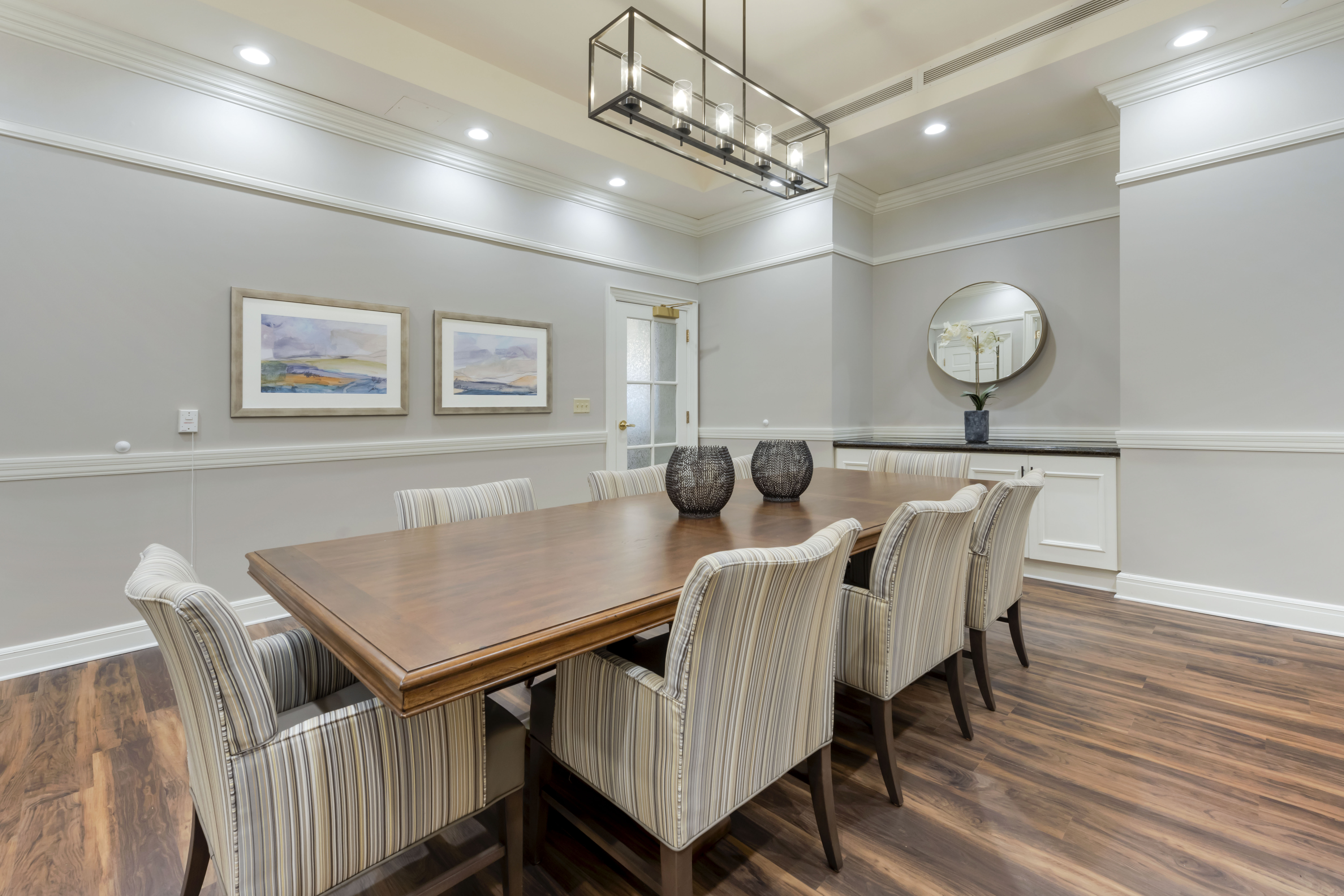 A well-lit dining room with a large wooden table