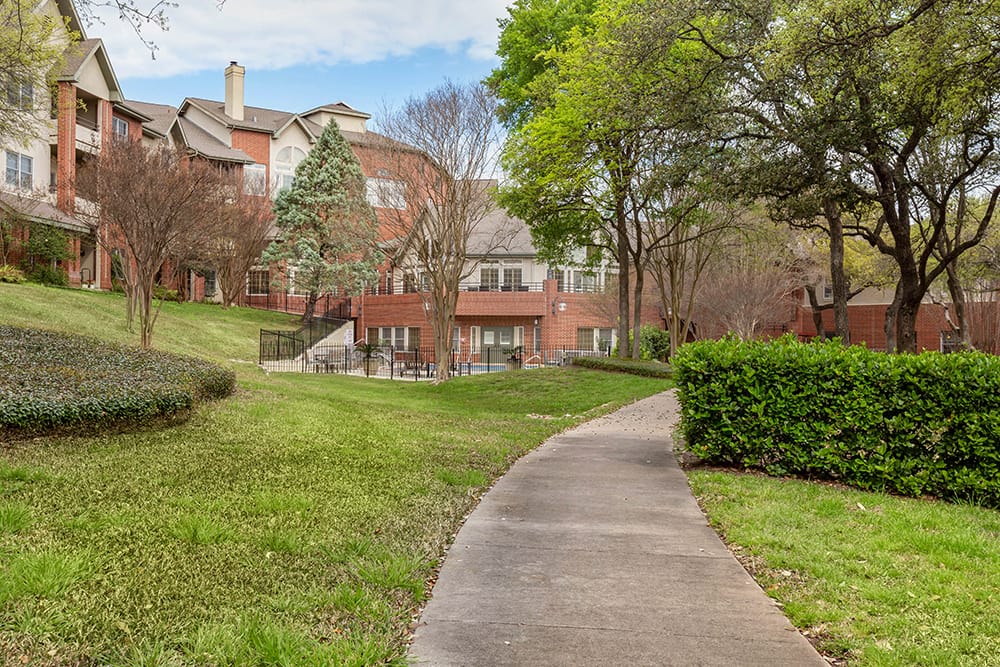 Pathway through landscaped outdoor space at a senior living facility