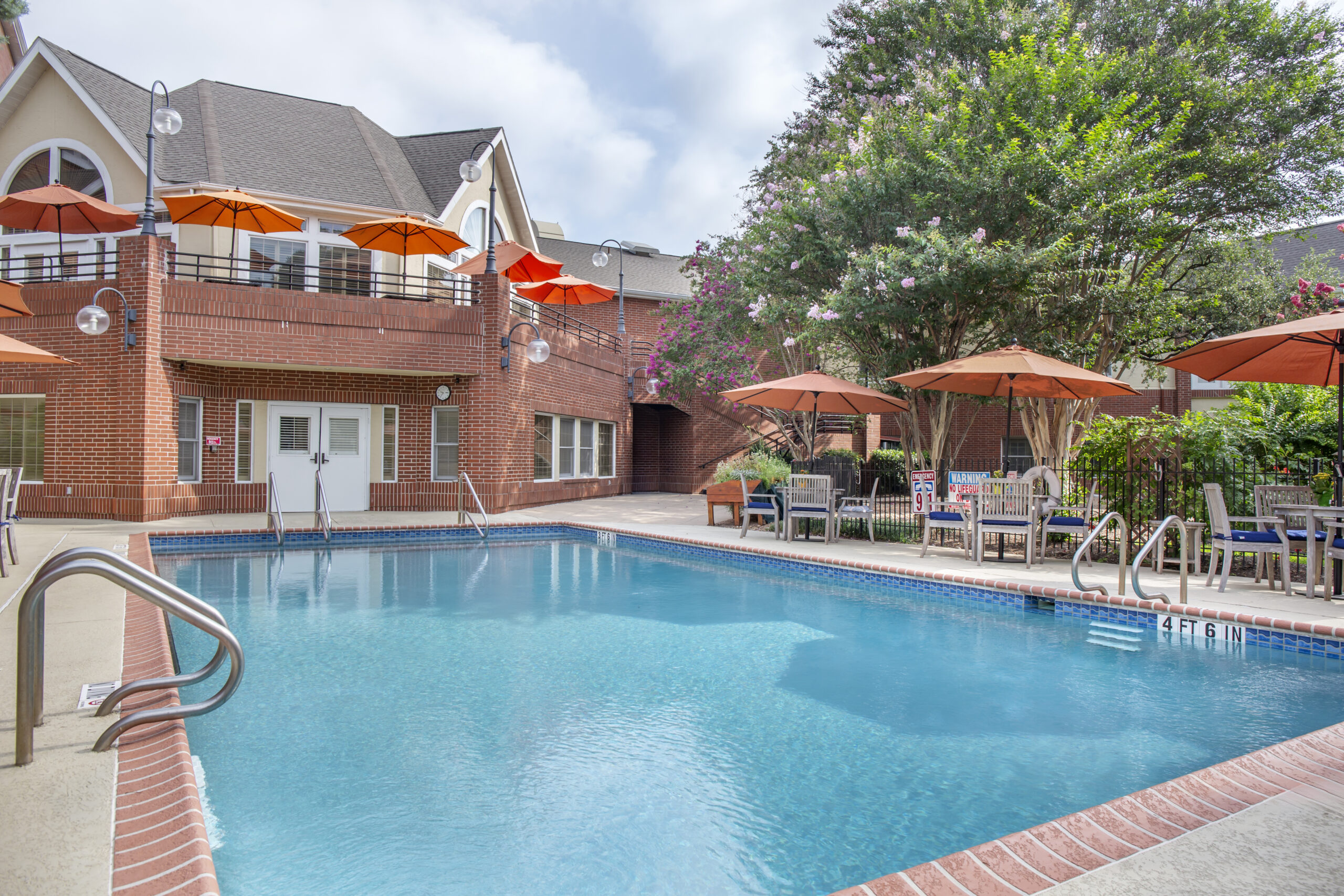 Outdoor pool area with seating and umbrellas