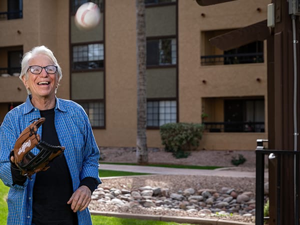 Resident playing catch outdoors in a vibrant setting