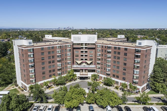 Aerial view of a senior living facility building surrounded by trees