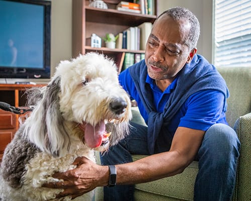 A resident interacting with a dog in a common area