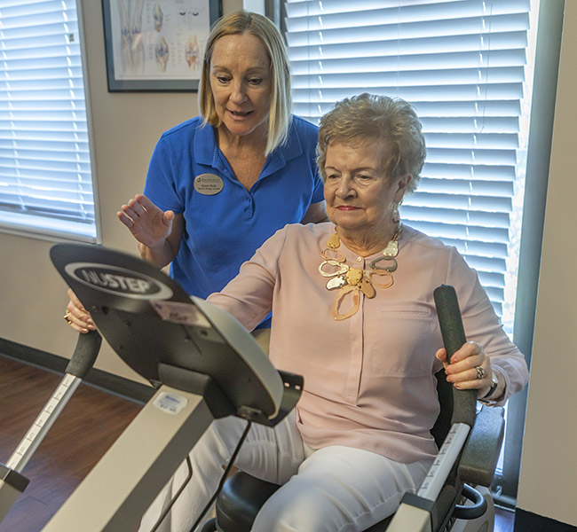 Staff assisting a resident on a fitness machine
