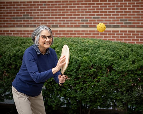 Resident enjoying an outdoor activity with a paddle