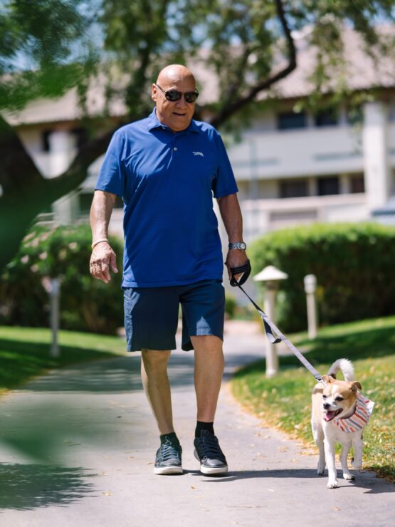 A resident walking a dog along a pathway