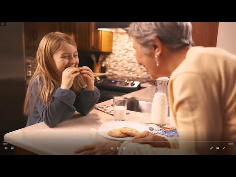 A woman and a girl enjoying cookies together in a kitchen