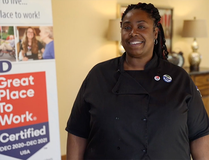 Staff member in a common area with certification banner