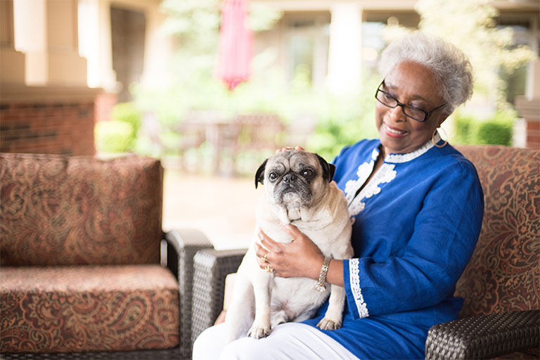 Resident enjoying time with a dog in a garden area