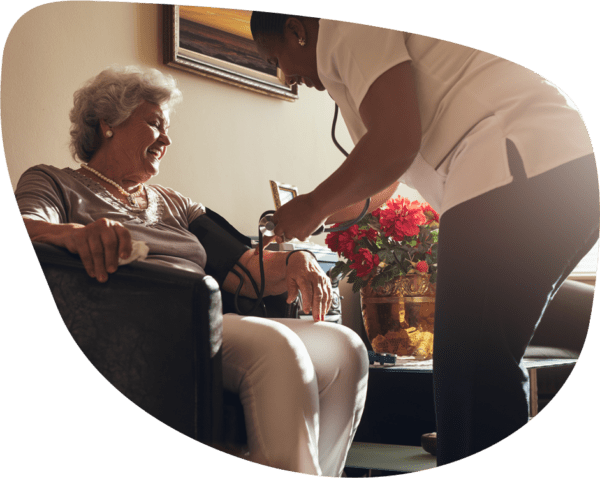 Nurse taking blood pressure of a smiling resident
