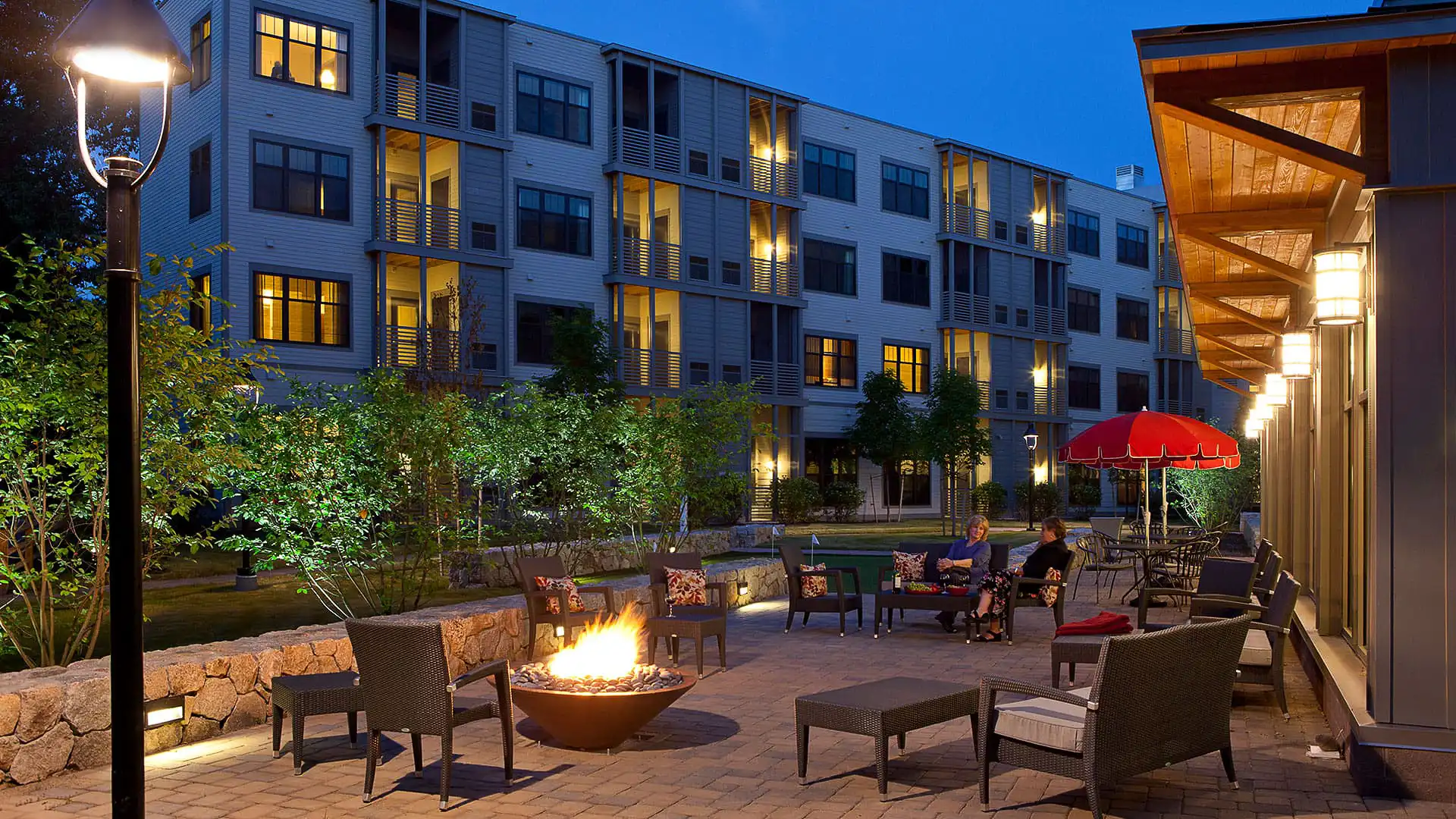 Residents enjoying an outdoor lounge area with a fire pit