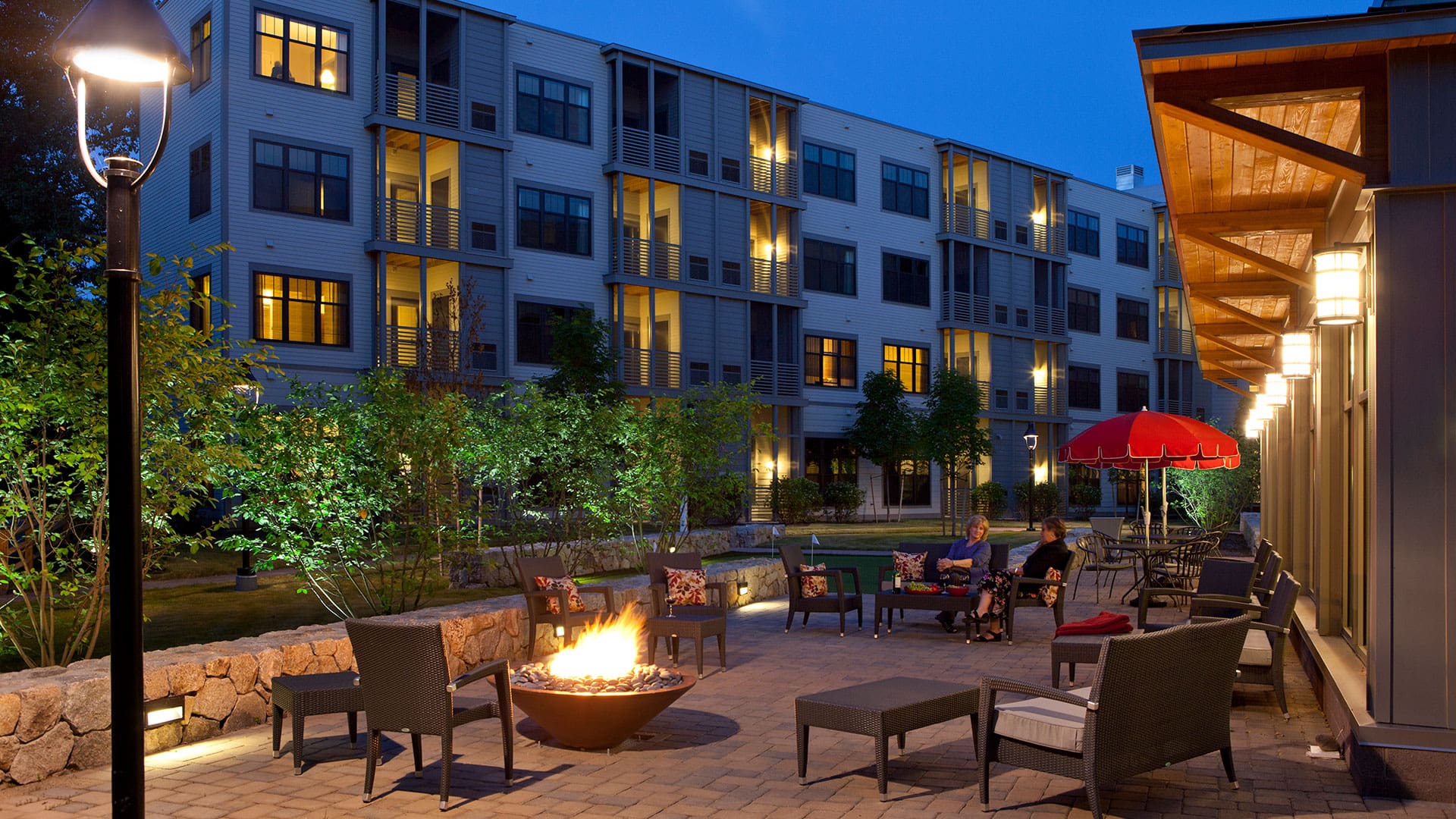 Residents enjoying the outdoor seating area by a fire pit