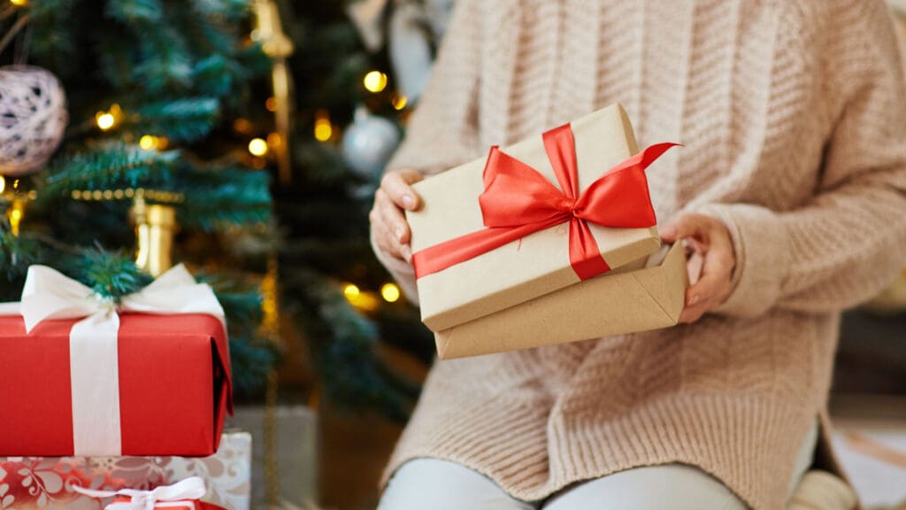 Resident holding gifts in a cozy common area during holidays