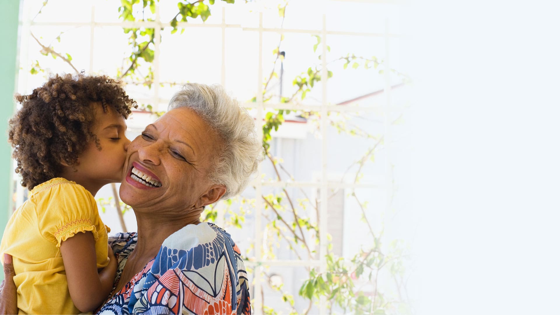 A joyful senior woman embracing a young girl
