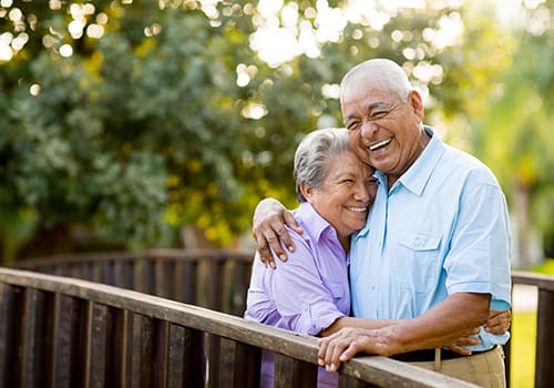 Happy senior couple embracing on a wooden bridge