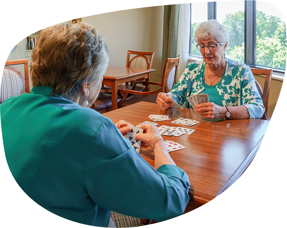 Two residents playing cards in a common area