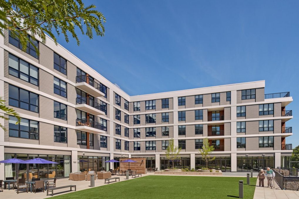 A modern assisted living building with outdoor seating