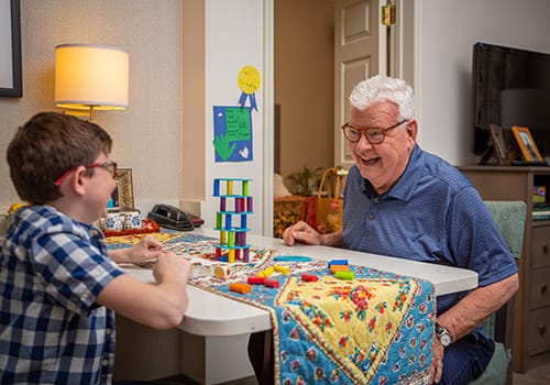 Elderly man and boy playing a game at a table