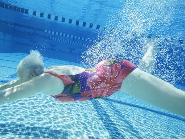 Senior woman swimming gracefully in a pool