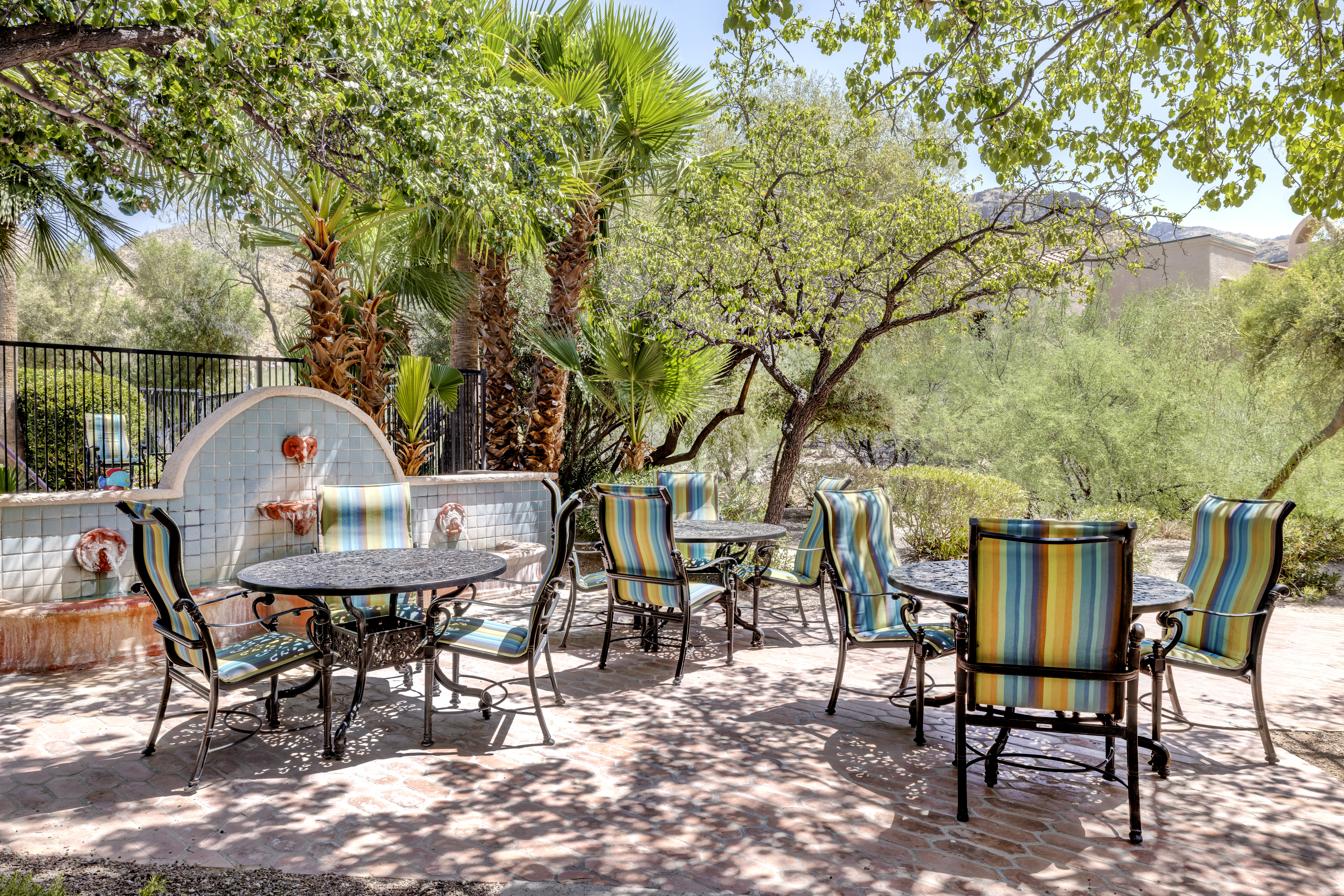 Outdoor seating area with colorful chairs and greenery.