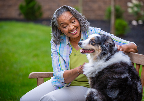 Resident enjoying time with a dog in the garden
