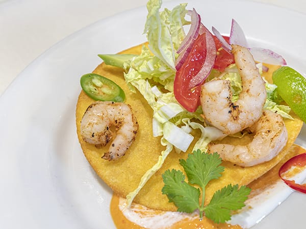 A plated shrimp dish with fresh toppings