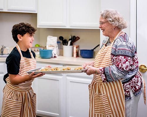 A resident and child baking in the kitchen