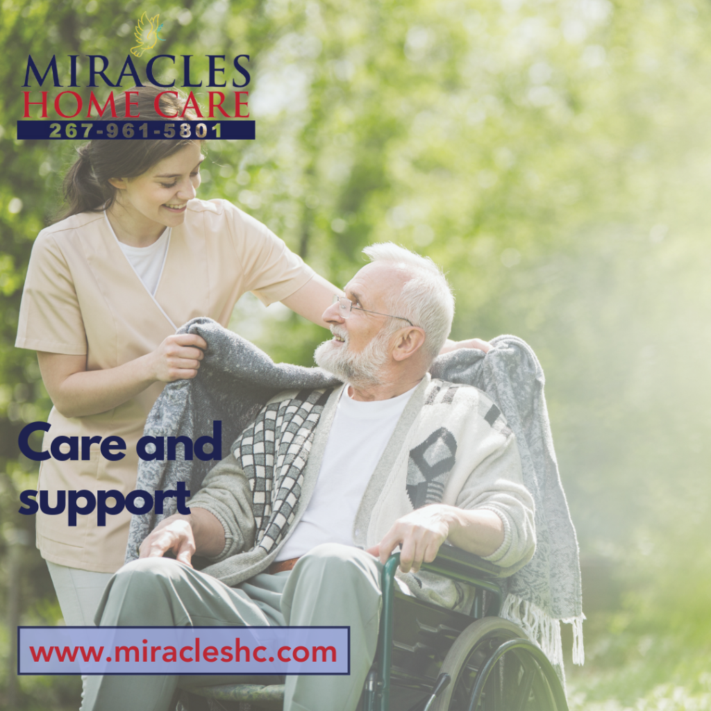 Caregiver assisting a senior in a park.