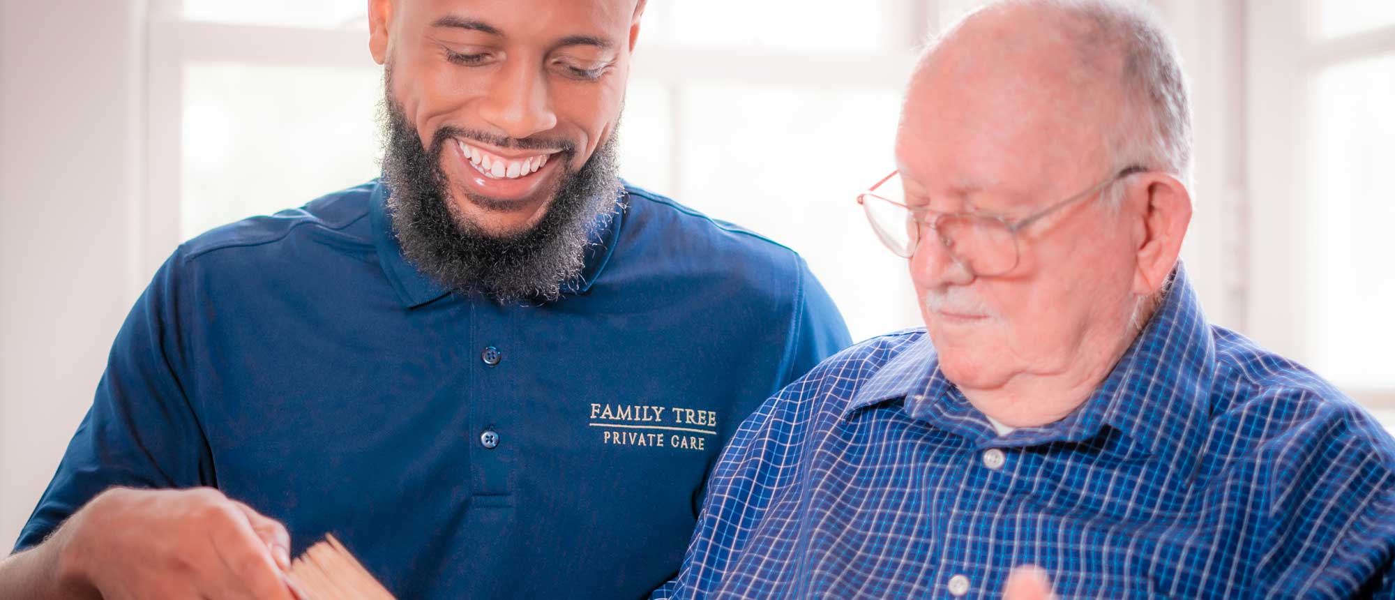 Caregiver assisting an elderly resident with a book