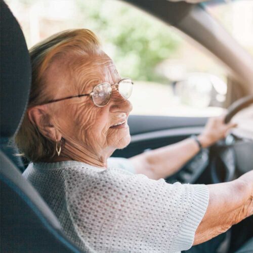Elderly woman driving a car.